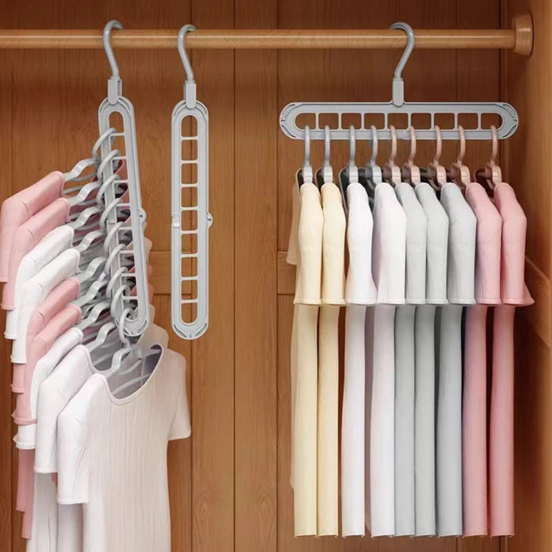 A set of three light-colored folding hangers displayed on a wooden rack.