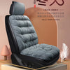 A dark gray plush car seat cover with a supportive backrest is displayed on a wooden platform.