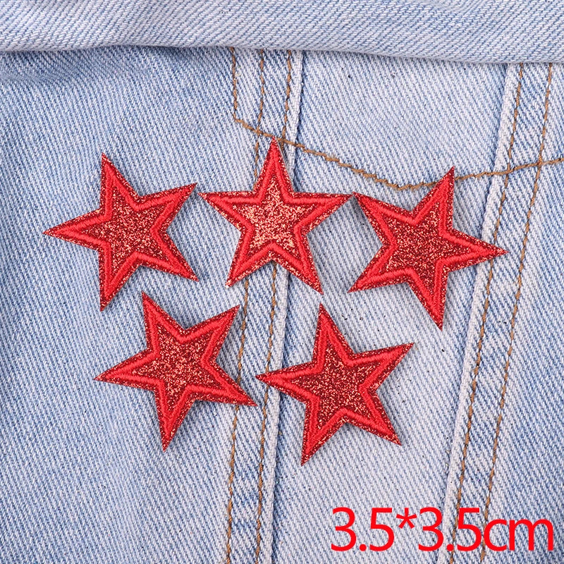 Set of five red glitter star iron-on embroidered patches on light blue denim fabric