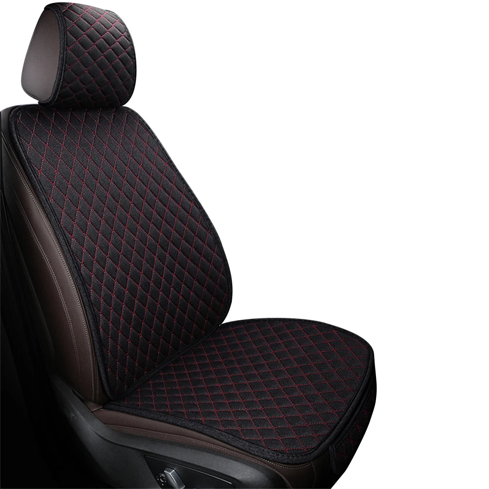 A close-up view of a black car seat cover featuring a quilted pattern with red stitching.