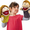A young girl is holding two soft hand puppets, one resembling a man and one resembling a woman.