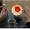 Hands hold a portable butane gas stove with a circular flame visible on the burner for a new product launch.