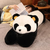 A large black and white panda plush toy is resting on a gray fabric next to a person reading a book.