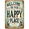 A vintage metal tin sign with distressed teal and orange lettering that reads Welcome to our Happy Place
