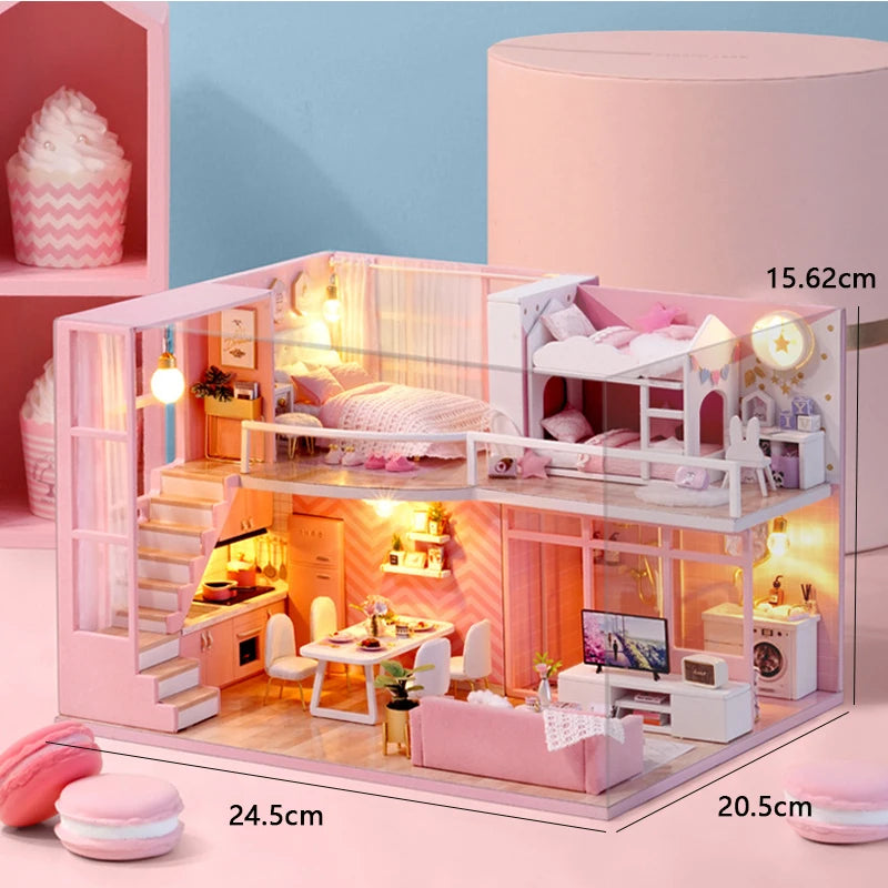 A pink wooden dollhouse miniature building kit with furniture displayed on a light pink surface.