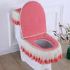 A pink antibacterial toilet seat cover set featuring a quilted cushion and ruffled fabric trim.