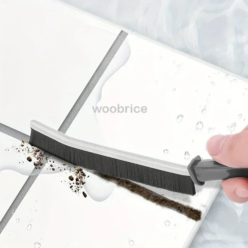 A black crevice cleaning brush is shown being used to clean a white surface, with water droplets visible.