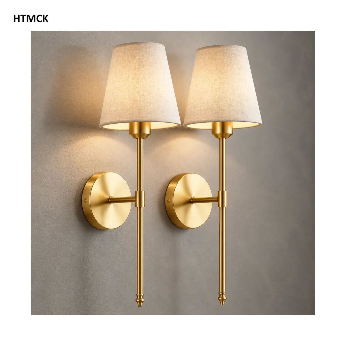 A pair of modern brass LED wall sconces with fabric shades mounted on a gray wall.