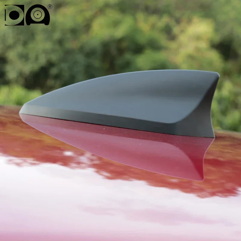 A car antenna featuring a shark fin design painted in piano paint, shown in profile.