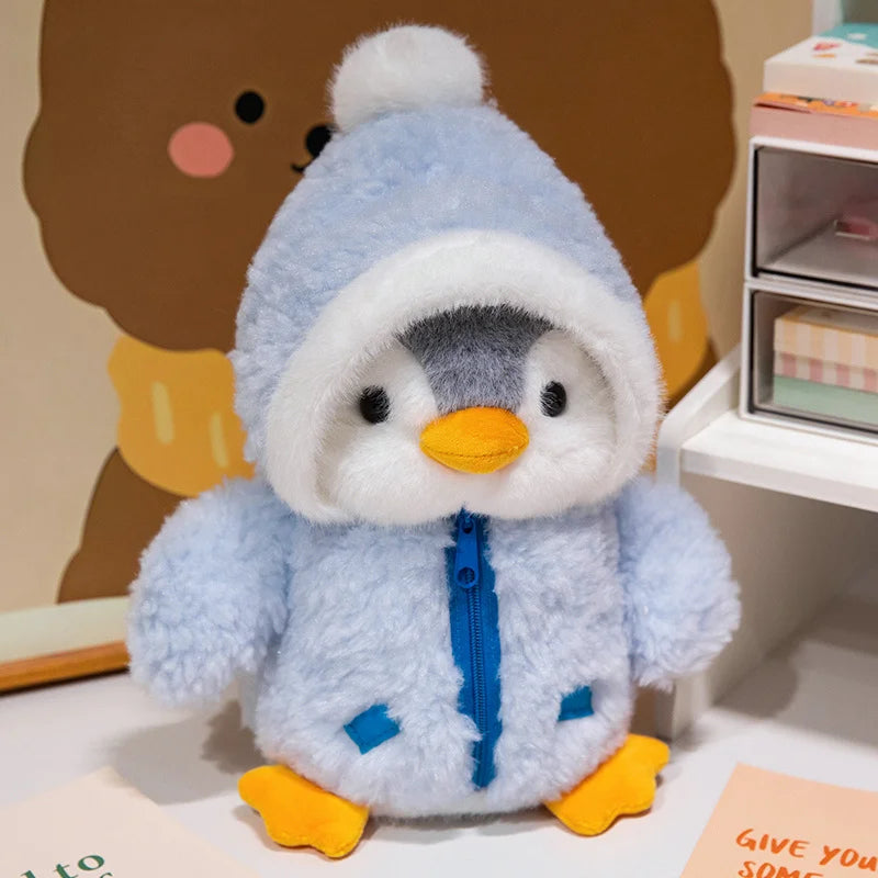 A fluffy blue penguin plush toy wearing a white hood and orange feet.