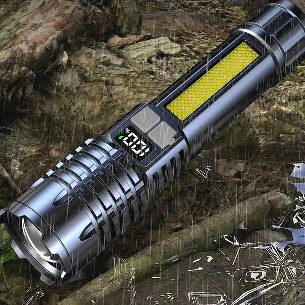 A silver high-power LED rechargeable flashlight with a yellow light strip is shown in a rainy outdoor setting.