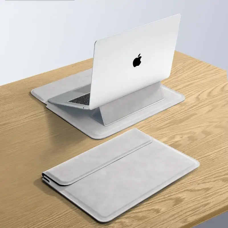A silver laptop sleeve case is shown resting on a wooden surface.
