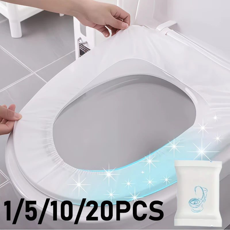 A white disposable toilet seat cover is being placed onto a toilet, with sparkling light emanating from the edge.
