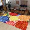 A colorful outdoor area rug featuring a tropical botanical pattern with shades of blue, yellow, orange, and red.