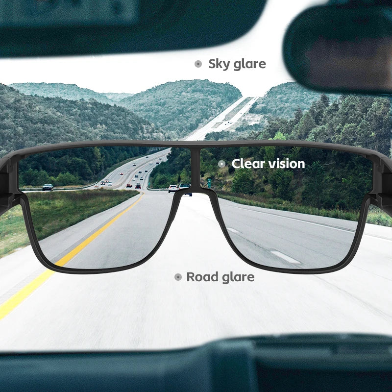 Polarized clip-on sunglasses showing clear vision and road glare on a scenic highway view.