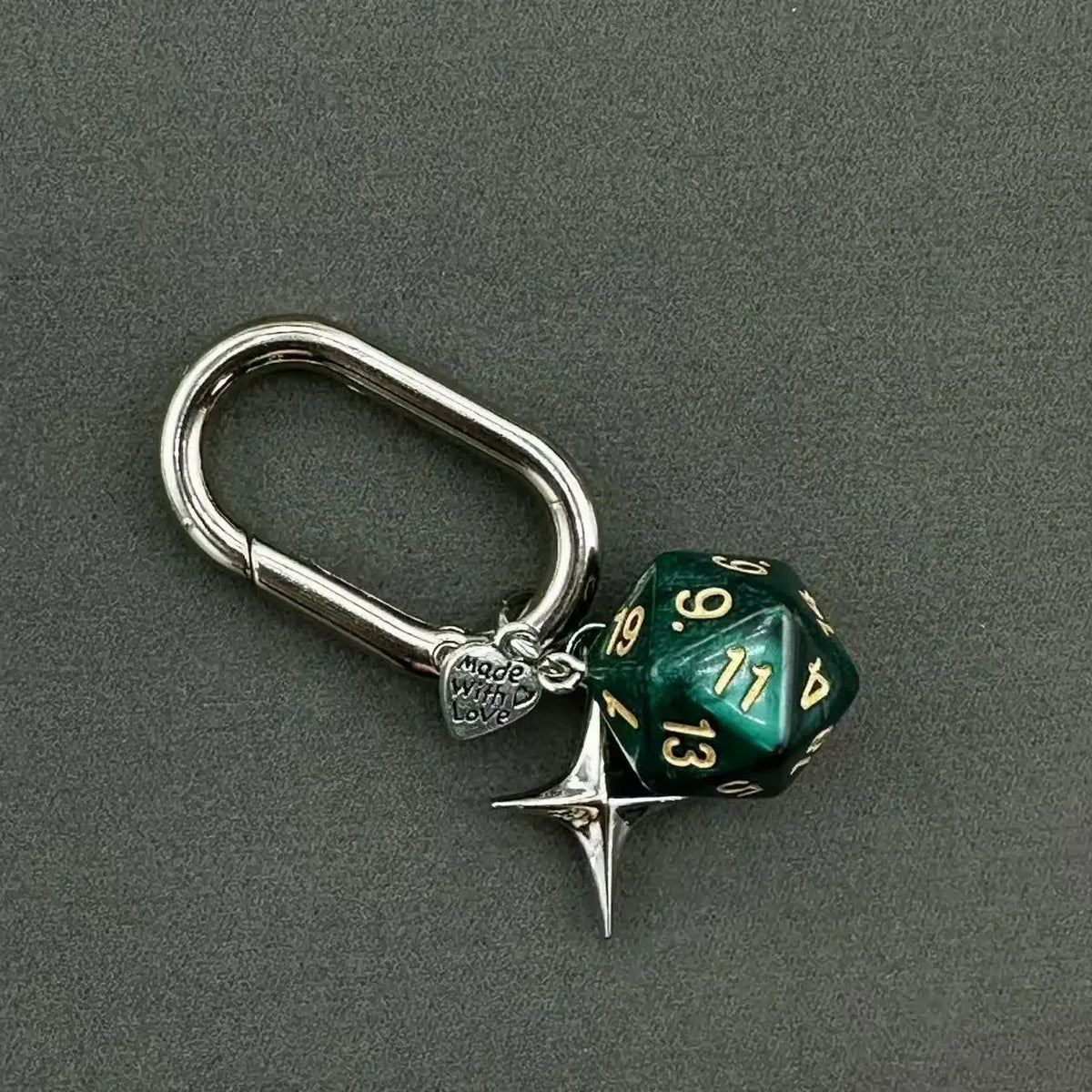 A silver D-shaped buckle keychain charm featuring a green dice with the number 13.