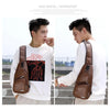 A young man wearing a white sweatshirt is shown holding a brown crossbody sling bag.