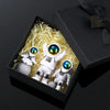 A set of three handcrafted astronaut figurines in a box with shredded yellow material and a black gift box.