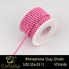 A spool of pink and magenta glass rhinestones used to create a cup chain for DIY clothing decoration.