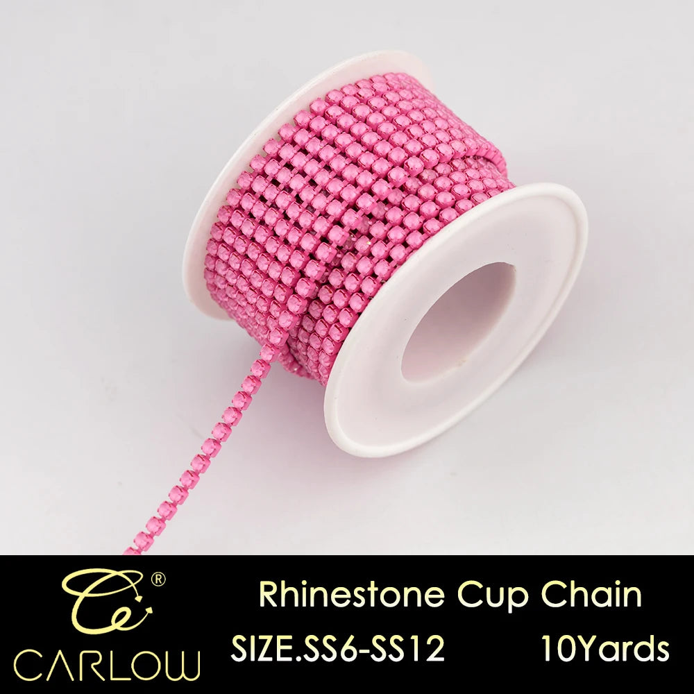 A spool of pink and magenta glass rhinestones used to create a cup chain for DIY clothing decoration.