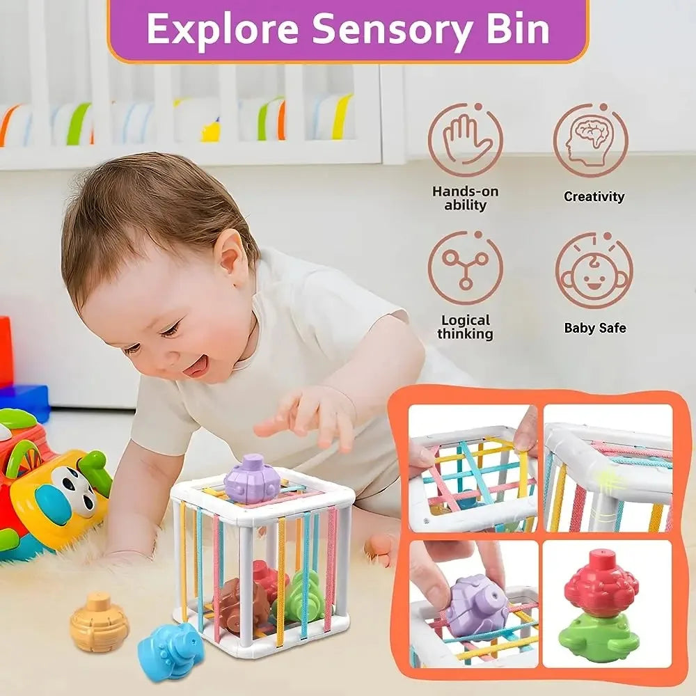 A baby is interacting with a sensory bin containing colorful shapes and toys, demonstrating hands-on learning.