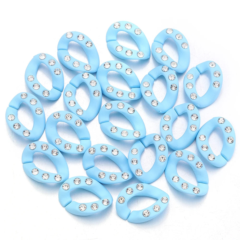 A set of twenty light blue acrylic jewelry connector clasps with crystal accents arranged on a white background.