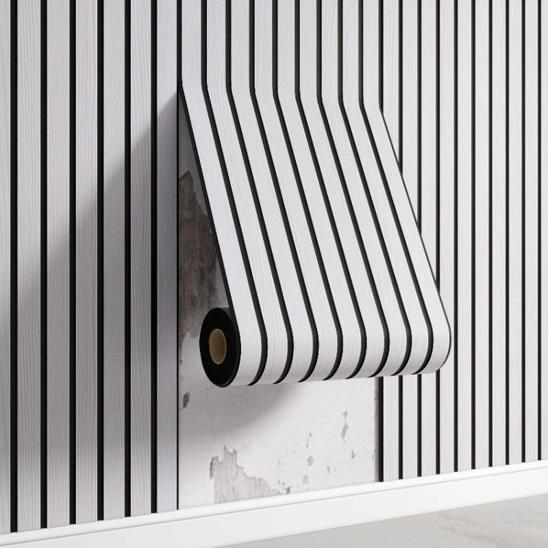 A roll of striped white and black self-adhesive wall panels mounted on a white shelf against a vertically striped wall.
