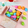 A box filled with colorful plastic Easter eggs in various shades of green, yellow, orange, and blue.
