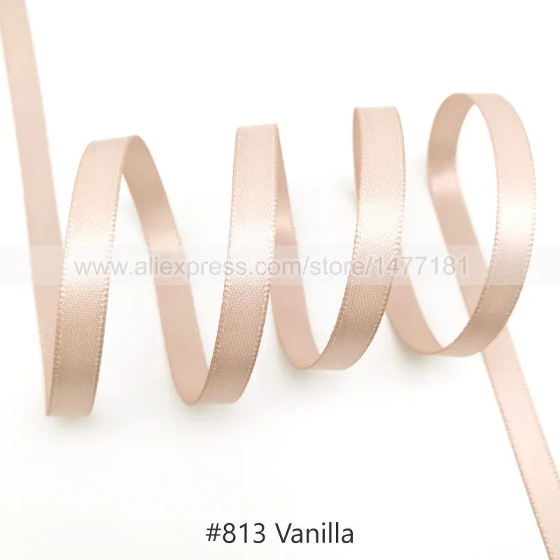 A roll of beige satin ribbon in vanilla color, shown looped and unwound.