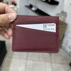 A maroon genuine leather slim card holder wallet with a white card inserted.