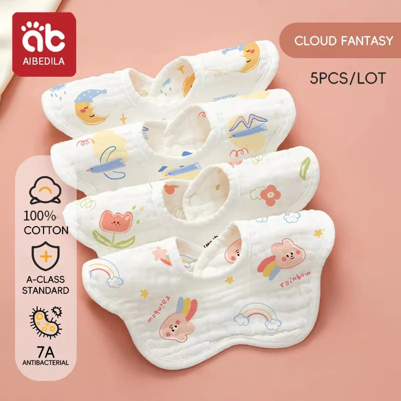A set of five white soft cotton muslin bandana bibs featuring various cute designs for babies