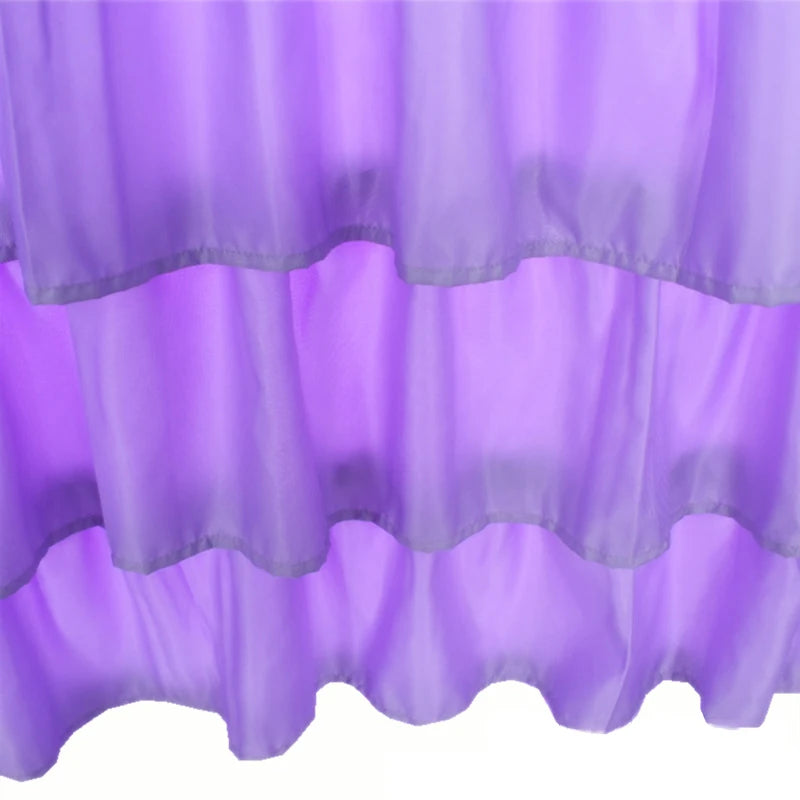 Purple sheer fabric bed skirt with ruffled hem, designed to wrap around a mattress.