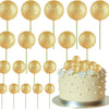 Eine Sammlung von zwanzig goldenen Glitzer-Ball-Kektoppern auf Stäbchen zur Dekoration.