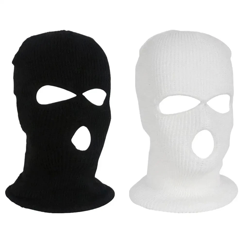 A pair of black and white ski mask car headrest covers.