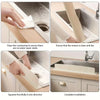 Hands demonstrate cleaning and installation of a flexible silicone sink splash guard on a kitchen countertop.