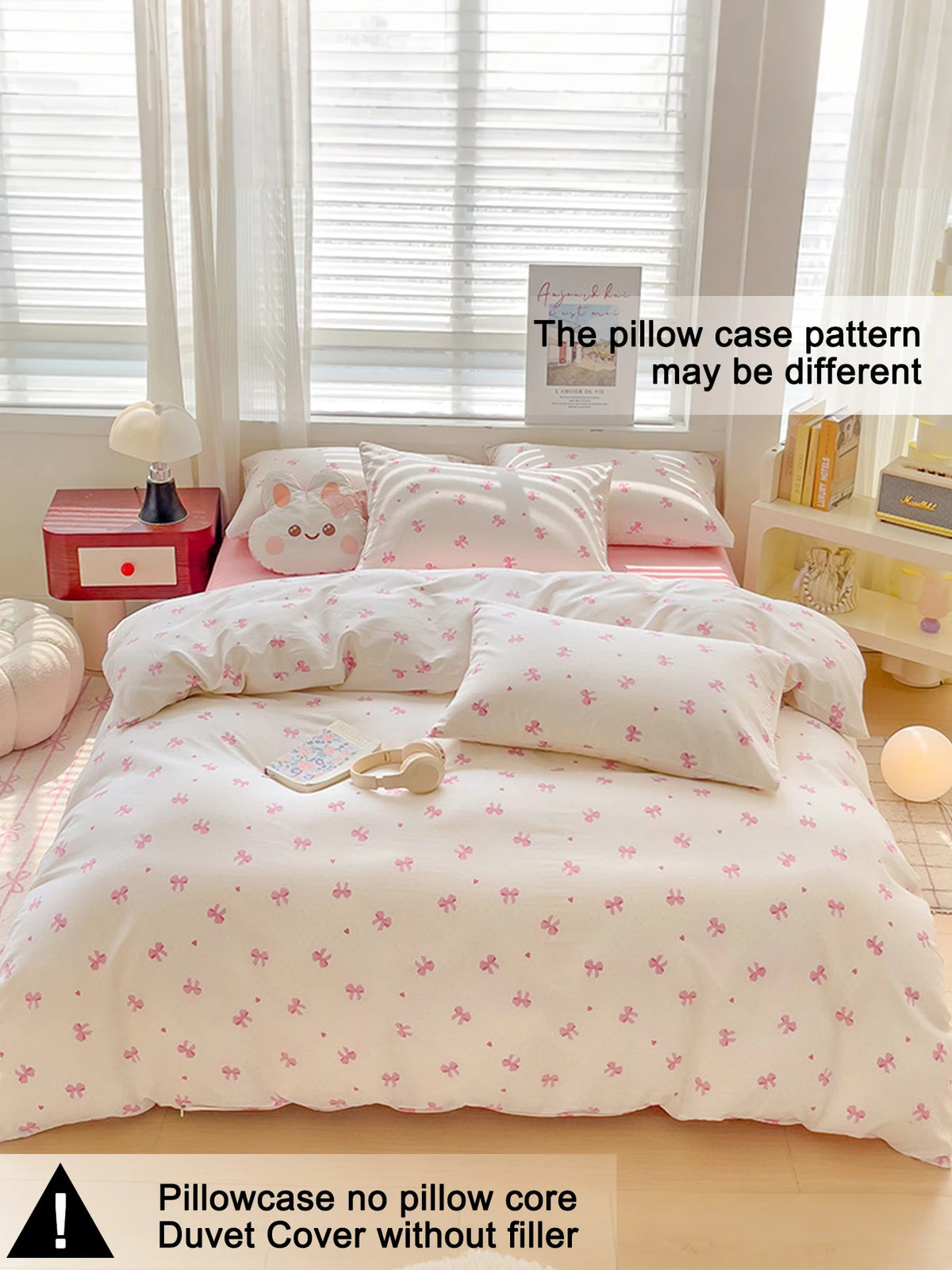 A pink duvet cover set with a white background and small pink bows is displayed on a bed, next to a window.
