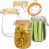 A set of wide mouth glass mason jars with orange lids and metal clasps, some filled with pickled cucumbers.