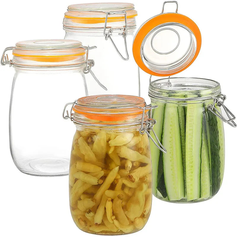 A set of wide mouth glass mason jars with orange lids and metal clasps, some filled with pickled cucumbers.