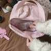 A person is opening a pink cosmetic travel organizer bag, revealing a padded interior and some makeup products.