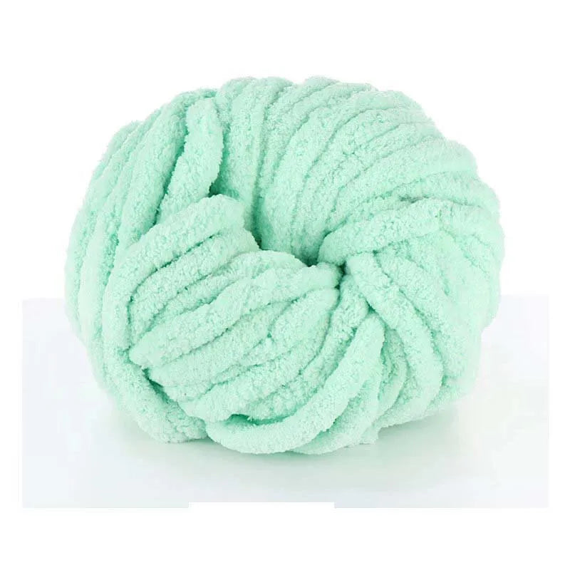 A ball of light mint green chunky chenille yarn used for knitting and crochet