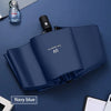 Navy blue automatic compact umbrella with UV protection feature shown open on a dark surface.