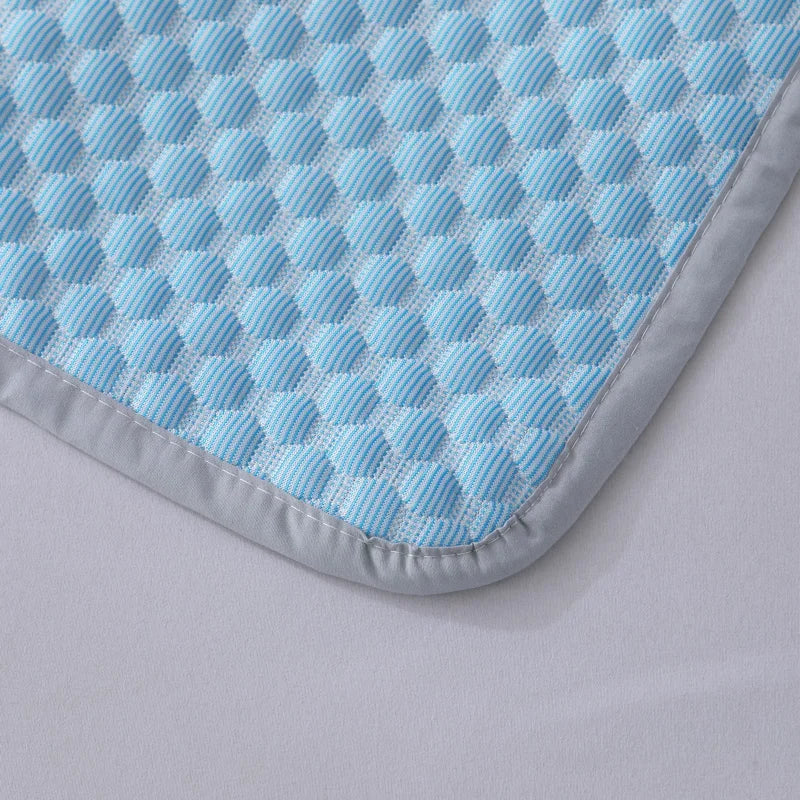 A close-up of a light blue and white checkered breathable cooling pillowcase with a gray trim.