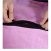Hands are opening a black zipper on a pink waterproof storage bag.