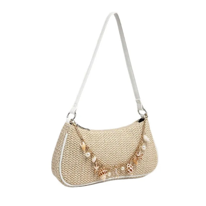 A beige straw beach shoulder bag with delicate ocean shell charms.