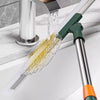 A silicone scraper broom and squeegee is shown pouring water over a sink basin.