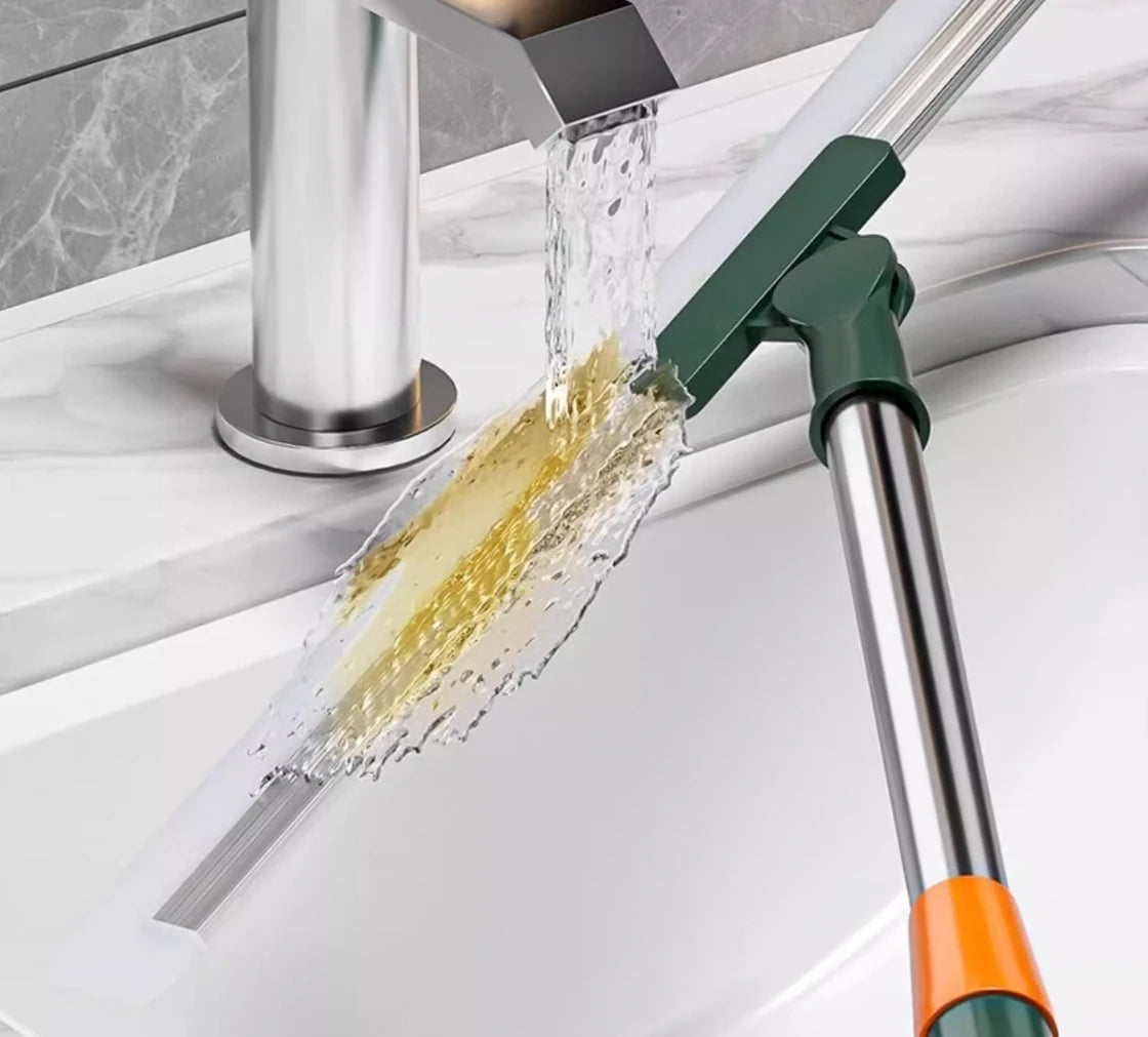 A silicone scraper broom and squeegee is shown pouring water over a sink basin.
