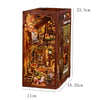 A wooden DIY book nook kit featuring a detailed miniature house scene with foliage and interior decor.