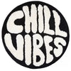 A round black carpet with white lettering that reads CHILL VIBES