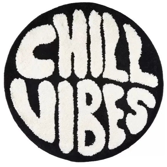 A round black carpet with white lettering that reads CHILL VIBES