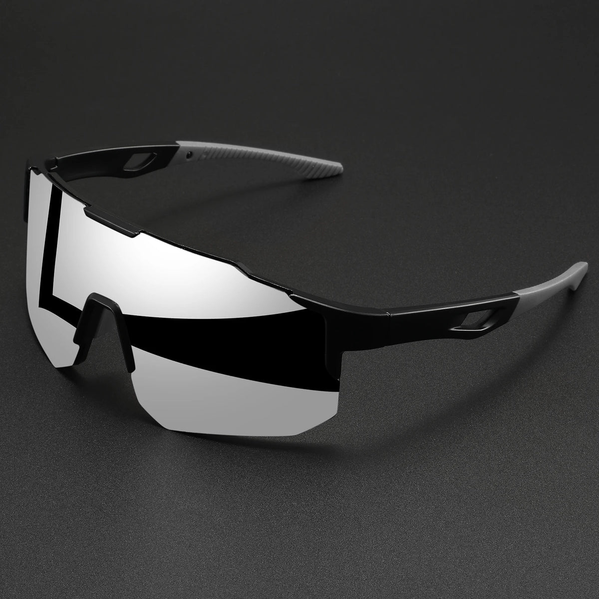 Paire de lunettes de sport oversize à monture enveloppante avec des verres noir et blanc, posées sur une surface sombre.